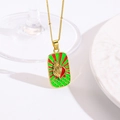 Gedetailleerde macro van gouden rechthoekige ketting met rood en groen emaille zonnestraal - Rood en Groen Zonnestraal Schelp Hart Halsketting (ZYN-DMK1153G-1A)