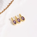 Detalle de tres colgantes ovalados de circón púrpura con base de metal dorado y aros redondos - Colgante Morado / Solo colgante