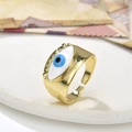 Makro-Detail des goldenen Evil-Eye-Rings mit blauem Emaille-Auge und Wimpernstruktur - Dunkelblauer Böser Blick Stil