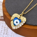 Detailopname van gouden hartvormige duivels-oog hanger met zirkonia op een dienblad - Prachtig Hart Oog Stijl (Met Ketting) (ZYN-DMK560G-6-A)