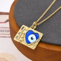 Detail van gouden Evil Eye ketting met blauw hart en zirkoon op metaal met hamerslagtextuur - Helderblauwe Hart Ketting (ZYN-DMK558G-7-A)