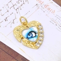 Macro detail van de gouden hart hanger met boze oog motief en zirkonia op briefkaart - Blauwe Oog Stijl (Alleen Hanger) (ZYN-DMK560G-2)