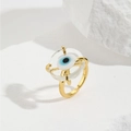 Macro shot of gold plated evil eye open ring on white stone background texture - Transparent (ZYN-DMR146G-6)
