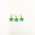 Detailed close-up of three gold five-pointed star pendants with micro-pave teal zircon gems - Teal Star Pendants Set