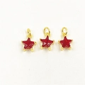 Close-up of three red star-shaped zircon pendants with gold-plated edges and ring loops - Red Star Pendants Set
