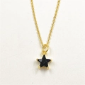 Macro detail of a black star pendant with gold metal frame and sparkling zircon inlay - Black Star Necklace