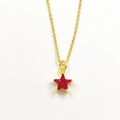 Close-up of gold star necklace pendant featuring a micro-paved red zircon stone detail - Red Star Necklace