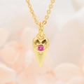 Gedetailleerd zicht op een goudkleurige boze oog hanger met roze zirkoon aan een ketting - Hanger met Ketting / Rozerood