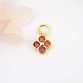 Detailed macro view of a gold four-leaf clover pendant with red zircon stones on white background - True Red Flower Style (ZYN-DMK272G-4)