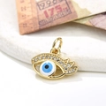 Macro detail of gold evil eye pendant with micro-set zircons and blue enamel charm - Blue Eye Style (ZYN-DMK530G-5)