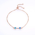 Rose gold adjustable box chain bracelet with blue opal dumbbell design on white background - Rose Gold Blue Opal Bracelet
