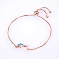 Macro shot of dolphin charm with blue opal stone on a rose gold box chain bracelet - Pisces / Rose Gold Blue