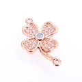 Macro detail of a four-leaf clover connector with rose gold plating and opal center - White Clover / Rose Gold