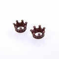 Makro-Detail von Bronze-Kronenanhängern mit Vintage-Relieftexturen für DIY-Schmuckherstellung - Antik-Kupfer
