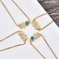 Close-up of gold plated boy and girl pendants with sparkling zircons and opal stones - Blue Opal (Bracelet) / Gold Color Girl