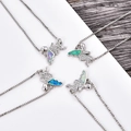 Detalle macro de colgantes de ángel hechos a mano con alas de ópalo y cadena fina - Pulsera Ángel de Platino Opalo Azul (B077A)