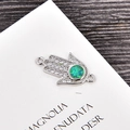 Makroaufnahme von Hamsa-Verbinder mit grünem Opal und funkelnden weißen Zirkonia - Platin Grün Opal Hand-Verbinder