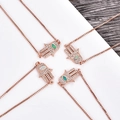 Vista de detalle de dijes mano de Fátima en oro rosa con pavé de circonitas y ojo de ópalo - Pulsera Oro Rosa