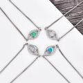 Makro-Detail von Teufelsauge-Anhängern mit Opalsteinen und Zirkonia in quadratischen Ketten - Blauer Opal / Weißgold Auge Armband
