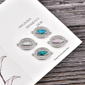 Detailed macro view of four opal eye charms with micro-pave cubic zirconia on wood background - Blue Opal / White Gold Evil Eye