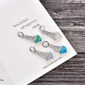 Détail de quatre pendentifs cœur en opale avec zircons sur carte d'affichage - Opale bleue / Cœur de Ton Argent 2
