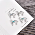 Set mit vier silbernen Pferdependeln mit Opal-Inlay für DIY-Schmuck auf Holzoberfläche - Blauer Opal / Zubehör / Silbernes Pferd