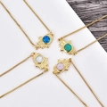 Close-up of Hamsa Hand pendants with colorful opal stones on gold box chains - Gold Plated Bracelet