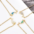 Close-up of dolphin pendants with colorful lab-grown opal inlays on box chains - Gold Dolphin Bracelet