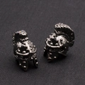 Spartan helmet studs in gunmetal finish with colored inlays on a gray fabric background - Gun Black