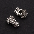 Macro shot of vintage silver dragon head alloy beads with intricate scale details for DIY jewelry - Antique Silver