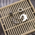 Detailed view of vintage silver crocodile charms with Love engraving on a textured background - Realistic Crocodile Shape Style (DM-PP-37)
