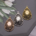 Detailed teardrop hollow metal pendants in gold silver and rose gold finishes - Straight Texture