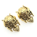 Detail shot of vintage gold skull beads with spiral patterns for DIY jewelry making - Antique Gold
