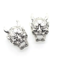 Macro shot of silver Hannya demon charms showing detailed horns and facial textures - Antique Silver