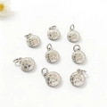 Detailed view of eight silver football charms with geometric textures for DIY jewelry - White Football