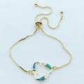Detailed macro view of the adjustable dolphin bracelet with turquoise opal stone inlays - Blue Opal Gold Plated