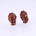 Macro shot of antique red copper Buddha head beads with detailed facial carvings - Antique Red Copper