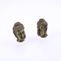 Macro detail of antique bronze Buddha head charms for DIY jewelry and bracelets - Cyan Bronze