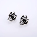 Punk style silver skull stud earrings with retro oxidized finish on white background - Antique Silver