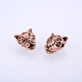 Macro detail of two vintage bronze leopard head beads for DIY jewelry and bracelet making - Antique Rose Gold