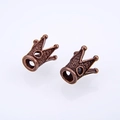 Macro detail of antique bronze crown-shaped alloy beads with textured surface for DIY jewelry - Antique Red Copper