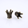 Macro detail of vintage bronze crown charms showing textured surface and threading holes - Cyan Bronze