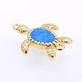 Dettaglio di un ciondolo a tartaruga dorata con opale blu e doppi anelli di aggancio - Oro Blu Opale