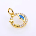 Primer plano detallado de un colgante de opale con forma de luna y baño de oro y circon - Dorado Azul