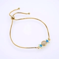 Makroaufnahme eines vergoldeten Schachtelketten-Armbands mit Opal-Anhänger und Zirkonia - Gold Blau Opal