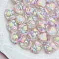 Close-up of DIY acrylic beads with colorful floral patterns and iridescent finish - Transparent Bead with Blue Heart and Yellow Bow