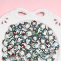 Macro view of Christmas themed beads with snowflake patterns in a white porcelain dish - Sold by Piece / Clear Bead with White Green Cream White Snowflake and Red Cherry