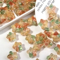 Primer plano de cuentas de estrella con pan de oro y texturas de colores para DIY - Verde Esmaltado + Rojo Ágata + Dorado
