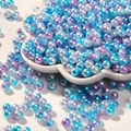 Gros plan de perles ABS irisées 6mm dans un plateau en fleur pour création bijoux DIY - 50g par paquet (env. 550 pcs) / Bleu-violet