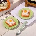 Macro view of miniature resin fried egg toast set with cute green plates and fork - Green Plate Fried Egg Toast